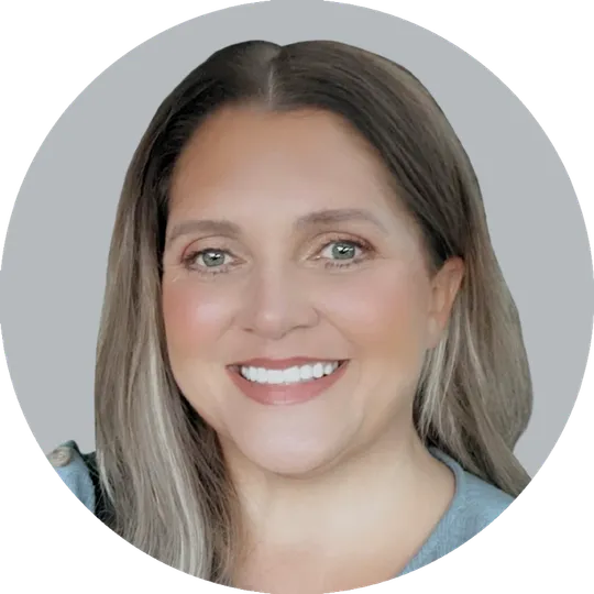 Portrait of Nurse Practitioner Erica Stanley wearing a light blue shirt, smiling with a light gray background