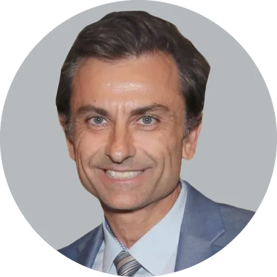 Portrait of Dr. Marcin Karcz wearing a gray suit, light blue shirt, and striped tie, smiling with a light gray background