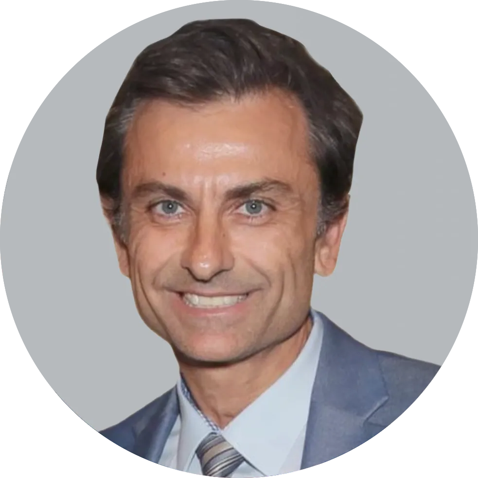 Portrait of Dr. Marcin Karcz wearing a gray suit, light blue shirt, and striped tie, smiling with a light gray background