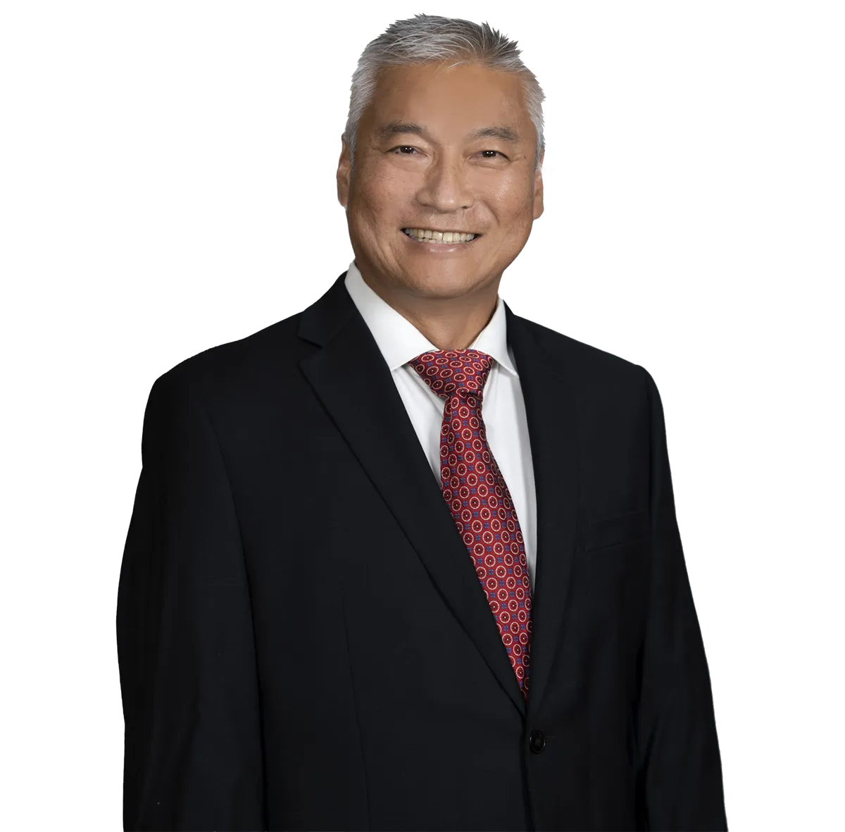 Portrait of Dr. Chris Kim wearing a black suit, white shirt, and red patterned tie, smiling