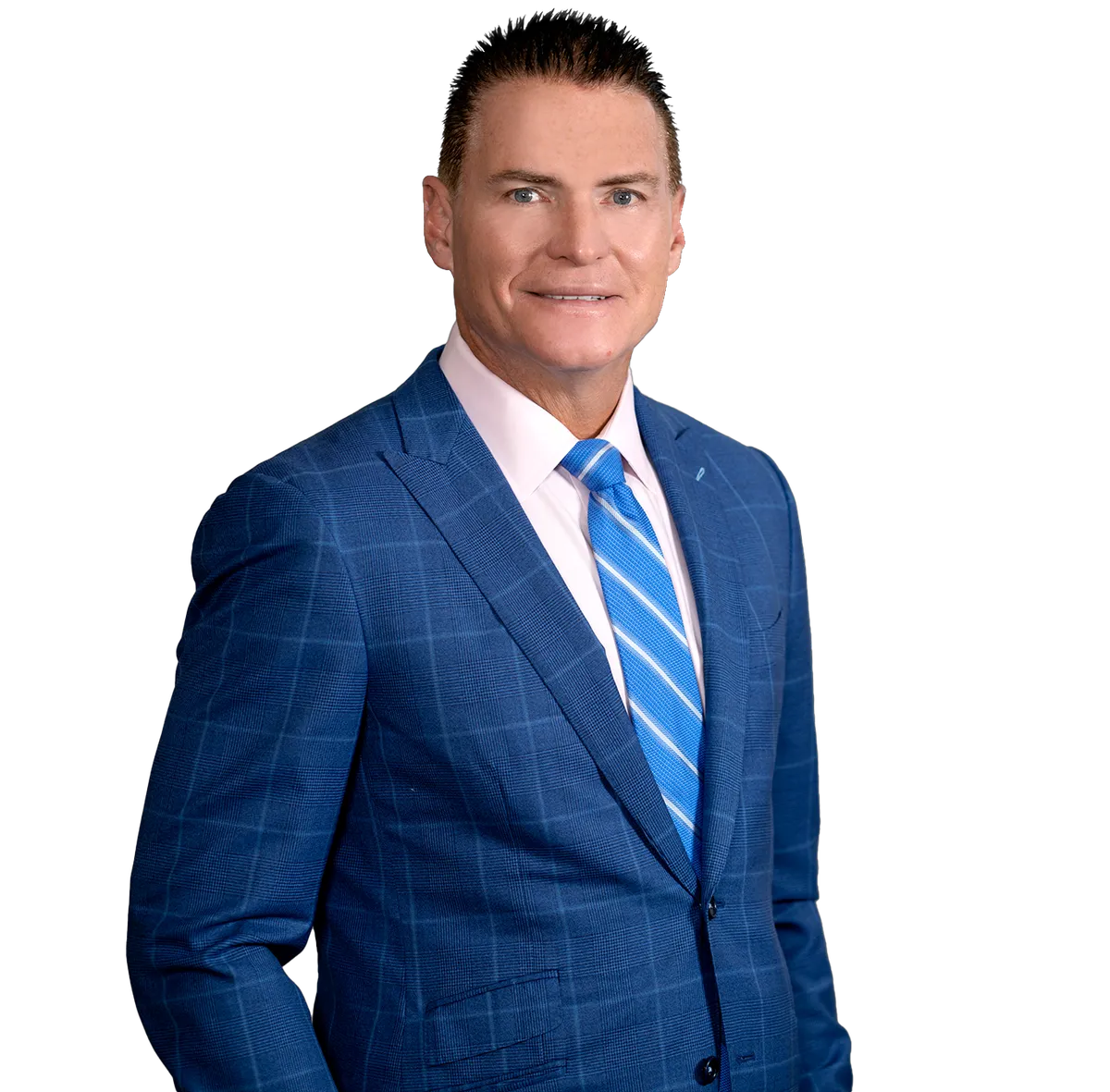 Dr Tim Deer in a blue checkered suit, light pink shirt, and blue striped tie is standing and smiling