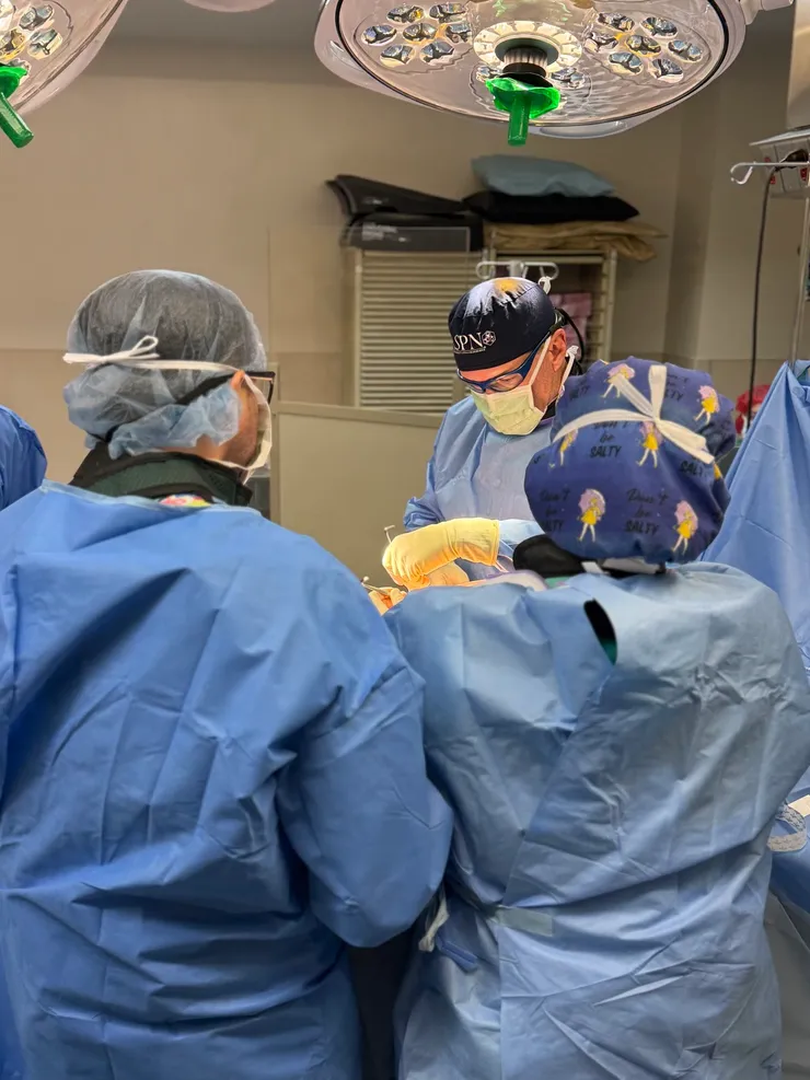 Dr. Timothy Deer, in an ASPN surgical cap, performing a procedure in the operating room with his surgical team