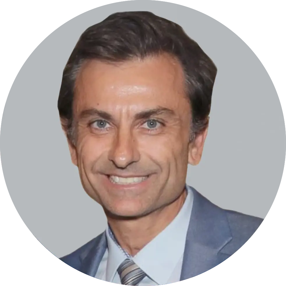 Portrait of Dr. Marcin Karcz wearing a gray suit, light blue shirt, and striped tie, smiling with a light gray background